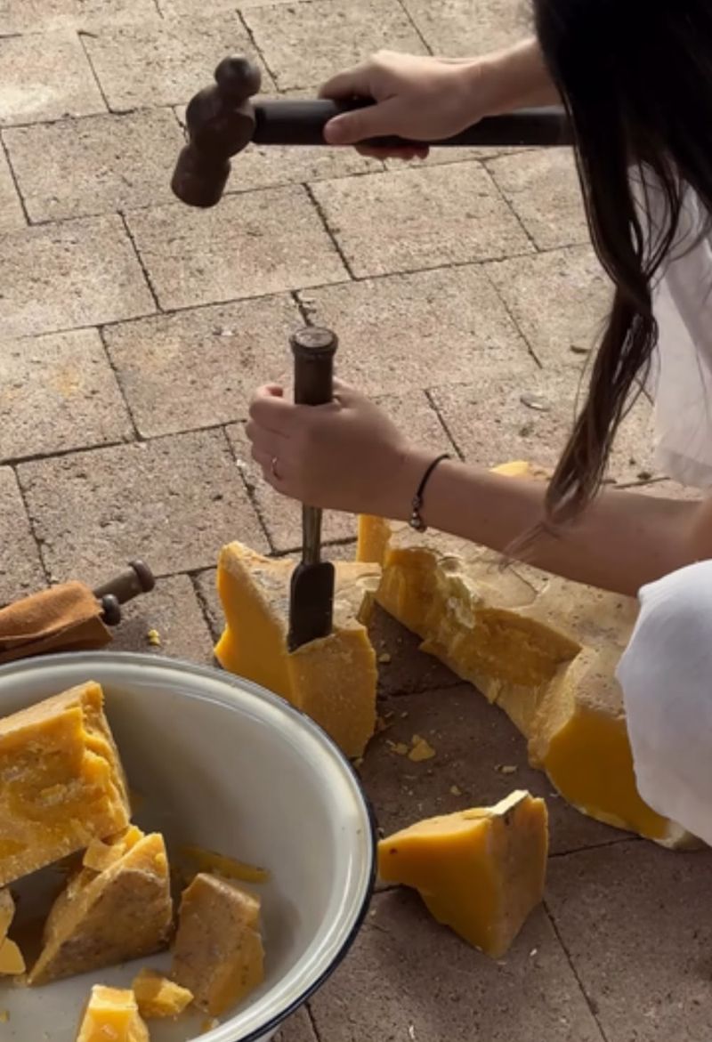 Blocos de cera de abelha sendo partidos à mão