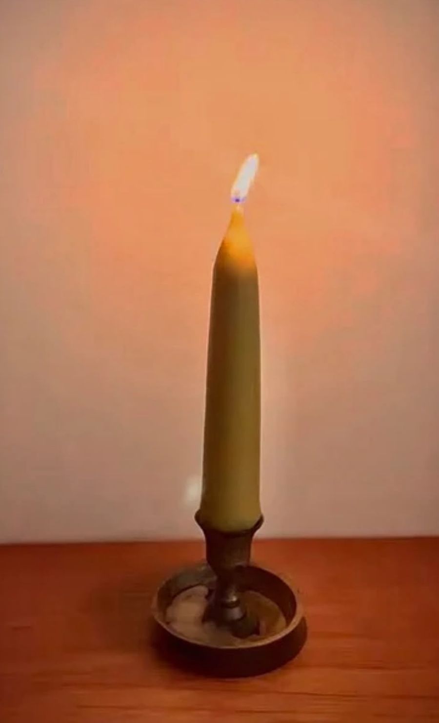 Vela de cera de abelha acesa em um castiçal